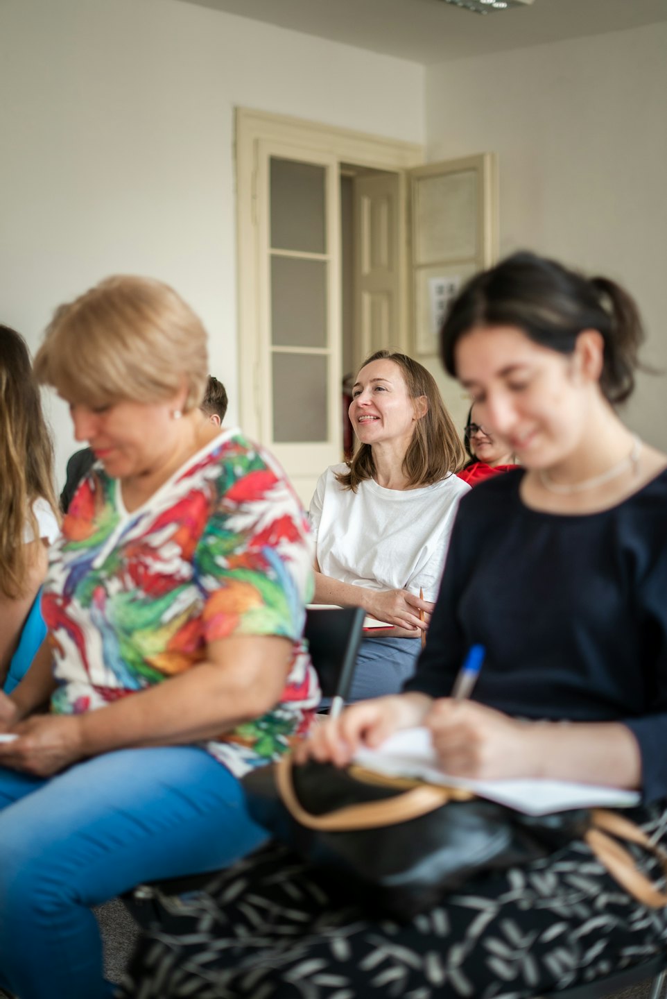 Teilnehmer in einem Workshop, die einem Redner aufmerksam zuhören.